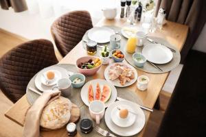a wooden table with plates of food on it at Aparthotel Viktorias Home in Kufstein