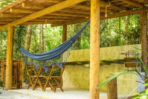 a hammock hanging under a wooden pergola at Chale 1 com Churrasqueira e Ar a 200m da Praia in Prado
