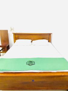 a bed with a green blanket on top of it at Forest Edge Yala Resort in Gotamegama