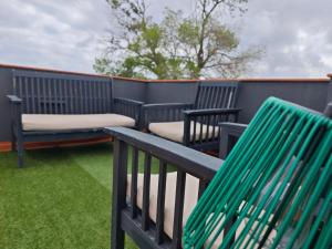 eine Stuhlreihe und eine Bank auf einem Balkon in der Unterkunft SeaSuites Blue-Ático con terraza chillout cerca del mar en Cullera in Mareny de San Lorenzo