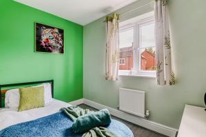 a green bedroom with a bed and a window at 4BD Spacious detached House in Birmingham suitable for Contractors and family's with free parking on private drive sleeps 9 in Birmingham