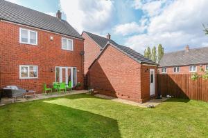 a brick house with a yard with green chairs at 4BD Spacious detached House in Birmingham suitable for Contractors and family's with free parking on private drive sleeps 9 in Birmingham