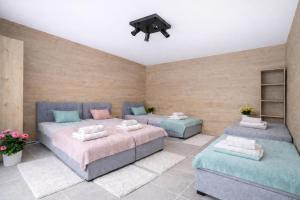 a bedroom with two beds and a tv on the wall at Całoroczny Domek Chill in Sława +7 photos