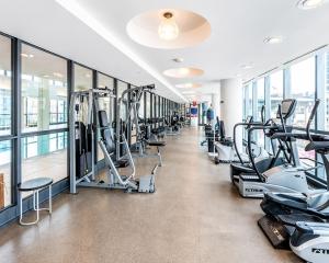 a gym with rows of treadmills and machines at 2 Bedroom Condo With City Views and Free Parking in Toronto