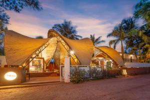a building with a curved roof at night at Marbela Beach Resort in Morjim
