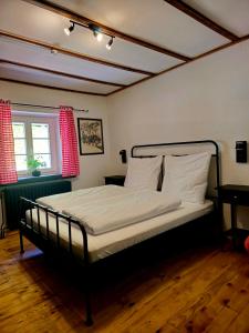 a bedroom with a bed with white sheets and a window at Konsdreffermillen B&B in Müllerthal