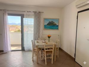a dining room with a table and chairs and a window at Casa Angela in Olbia