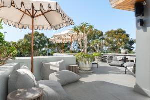 an outdoor patio with chairs and an umbrella at Point Break Luxury Apartments in Cape Town