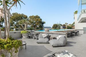an outdoor patio with tables and chairs and a pool at Point Break Luxury Apartments in Cape Town