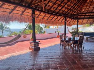 a patio with a table and chairs and a view of the ocean at Penthouse Bella Vista in Puerto Escondido
