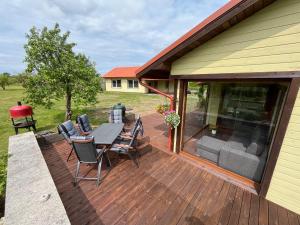 eine Holzterrasse mit Tisch und Stühlen an einem Haus in der Unterkunft Õuna in Ansi