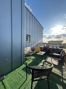 a balcony with chairs and tables on a building at T2 cosy proche Versailles in Trappes