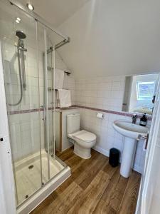 a bathroom with a shower and a toilet and a sink at 2A Lochy Crescent in Inverlochy +19 photos