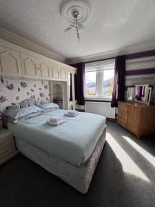 a bedroom with a large bed and a window at 2A Lochy Crescent in Inverlochy