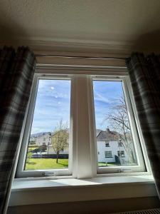 a window with a view of a house at 2A Lochy Crescent in Inverlochy