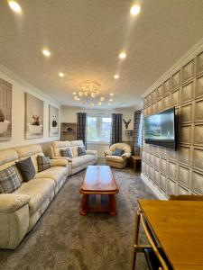 a living room with a couch and a table at 2A Lochy Crescent in Inverlochy