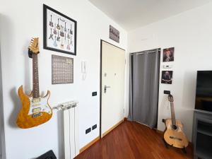 two guitars are hanging on a wall in a room at La Casa sul Serio in Seriate