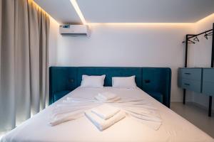 a bedroom with a blue bed with towels on it at Euphoria Apartments in Sarandë