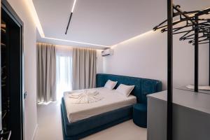 a bedroom with a bed and a blue chair at Euphoria Apartments in Sarandë +175 photos