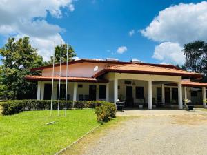 a building with a grass yard in front of it at Forest Edge Yala Resort in Gotamegama