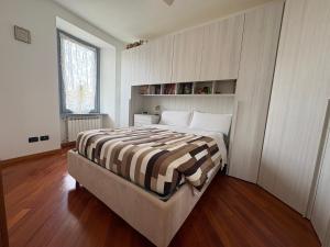 a bedroom with a bed with a striped blanket at La Casa sul Serio in Seriate