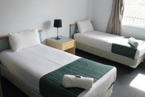 a hotel room with two beds and two lamps at Rocky Glen Hotel Motel Gladstone in Gladstone