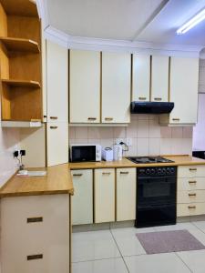 a kitchen with white cabinets and a black stove top oven at Golf Road Guesthouse in Pietermaritzburg +22 photos