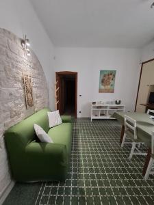 a living room with a green couch and a table at Domus Nicolaus in Giovinazzo