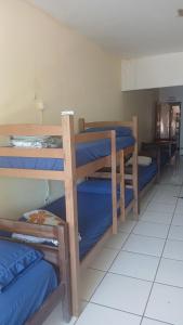 a room with three bunk beds with blue sheets at adriana hostel in Itacaré