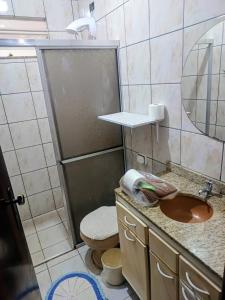 a bathroom with a sink and a toilet and a mirror at Harmonia Studio Mobiliado in Campo Grande