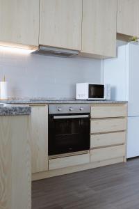 a kitchen with a stove and a microwave at Páteo da Chica in Cano