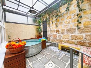 a hot tub in a room with a brick wall at Basso 61 Urban Oasis with Private Mini Pool & Courtyard - Families & Groups in Palermo