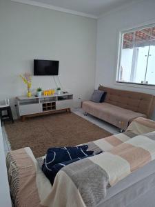 a living room with a bed and a couch at Bela Casa PX as praias in São Luís