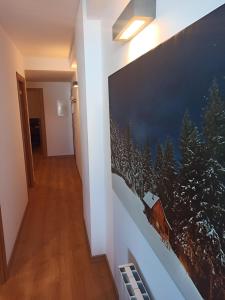 a hallway with a large painting on the wall at Altissim LaSolana in Pas de la Casa