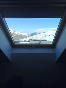 a window in a room with a view of a snow covered mountain at Altissim LaSolana in Pas de la Casa