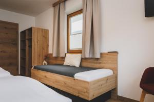 a bedroom with a wooden bed and a window at Apartpension Oberhauser in Kaprun +20 photos