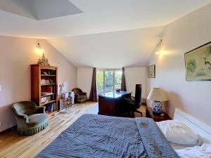 a bedroom with a bed and a desk in it at La Parenthese in Blyes