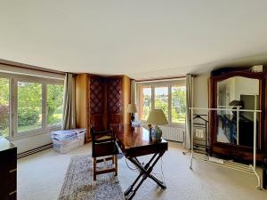a living room with a desk and a mirror at La Parenthese in Blyes