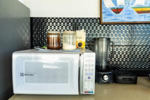 a microwave sitting on top of a counter next to a blender at Manhatã Hostel in Salvador