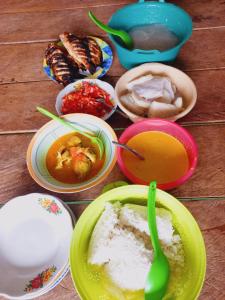 a table with plates of food and bowls of soup at Batu Mela Cottage in Banggai +26 photos