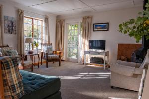 a living room with a couch and a tv at Olive's Cottage in Molteno