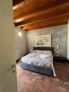 a bedroom with a bed and a wooden ceiling at Copelia - Pool and Elegance in Paratico +19 photos