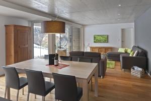 a dining room and living room with a table and chairs at Sera Lodge in Grächen