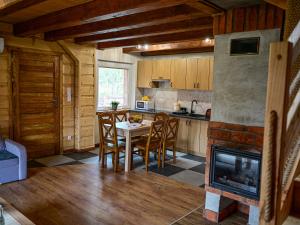 a kitchen with a table and chairs and a fireplace at Domki Markowa Dolina in Rymanów