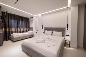 a bedroom with a large white bed and a couch at Euphoria Apartments in Sarandë