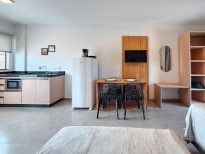 a kitchen with a small table and a refrigerator at Centro - flat completo para 4 pessoas in Brusque