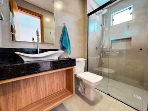 a bathroom with a sink and a toilet and a shower at Centro - flat completo para 4 pessoas in Brusque +13 photos