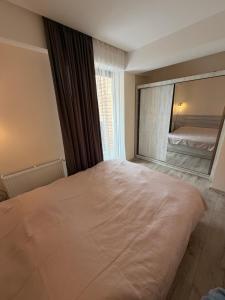 a bedroom with a large bed and a mirror at Bakuriani apartment in Bakuriani