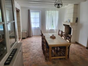 a dining room with a table and chairs and a fireplace at La Petite Rochette in Chédigny +6 photos