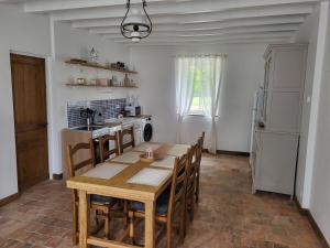a kitchen with a wooden table and chairs in a room at La Petite Rochette in Chédigny
